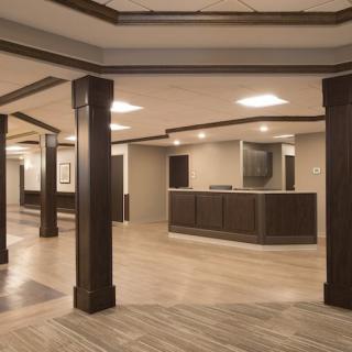 A modern reception area featuring dark columns and wooden flooring.