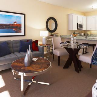 A modern living room and kitchen area with stylish furniture and decor.