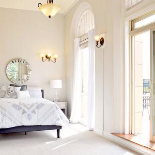 A bright and airy bedroom with large windows and modern decor.