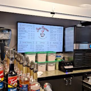 A view of a bar area showcasing a digital menu and various drink options.