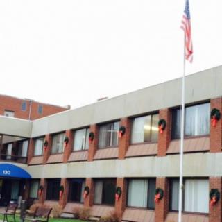 A two-story building with an American flag flying outside.