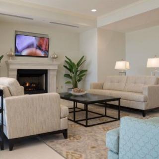 A modern living room with comfortable seating, a fireplace, and a wall-mounted TV.