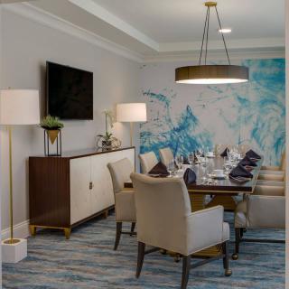 A modern dining room with elegant furnishings and abstract wall art.