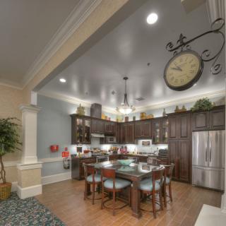 A modern kitchen interior with wood cabinets, an island counter, and stainless steel appliances.