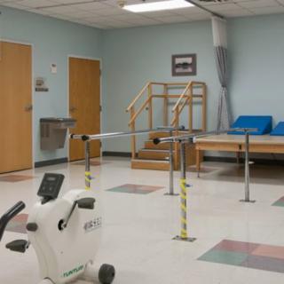 A rehabilitation room equipped with various physical therapy tools and exercise equipment.