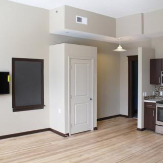 A modern apartment interior with an open kitchen and living space.