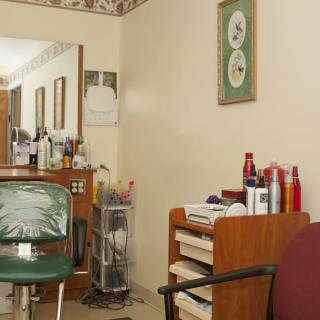 Interior of a hair salon with a chair, mirror, and hair products on display.