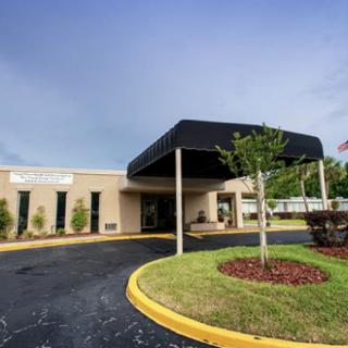 A building entrance with a covered canopy and landscaped surroundings.