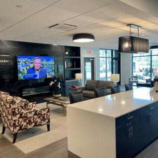 A modern lounge area featuring comfortable seating, a television, and contemporary lighting.