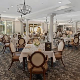 An elegant dining room with beautifully set tables and classic chandeliers.
