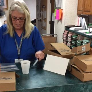 A woman organizing packages at her office desk.