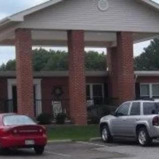 A building with brick columns and a parking lot with cars.