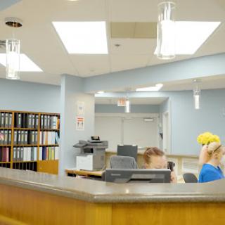 A reception area in a healthcare facility, featuring a desk and filing cabinets.