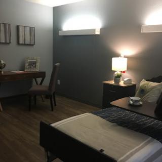 A modern bedroom with a cozy ambiance featuring a bed, desk, and stylish decor.
