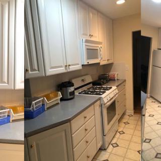 A view of a modern kitchen featuring white cabinets, a stove, and other appliances.