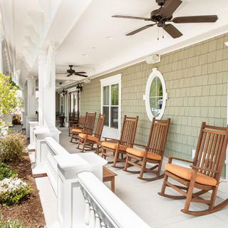 A welcoming porch with wooden rocking chairs and ceiling fans.