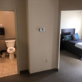 View of an apartment interior with a bathroom and bedroom.