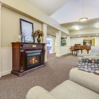 A cozy living room featuring an elegant fireplace and a piano, perfect for relaxation and entertainment.