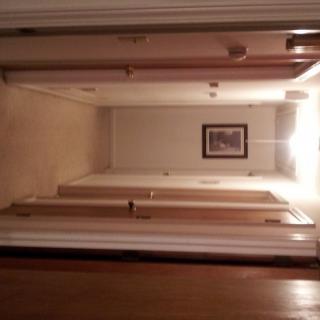 A well-lit hallway with multiple doors and a picture frame on the wall.