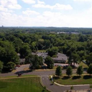 Aerial view of a landscape with lush greenery, buildings, and roads.