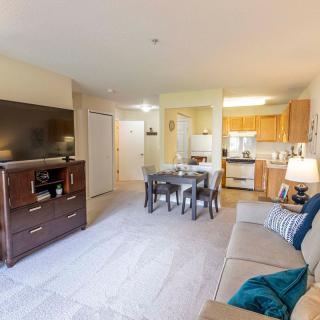 A modern living space with an open floor plan, featuring a cozy living room, dining area, and kitchen.