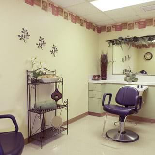 A cozy hair salon interior with a styling chair, mirror, and decorative elements.