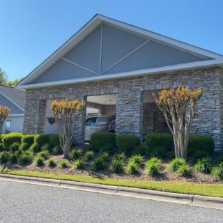 A modern building with a brick facade and well-maintained landscaping on a sunny day.