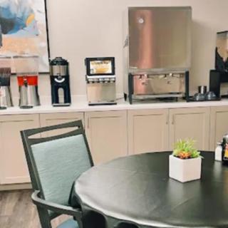 An office break room featuring a coffee station and a table with chairs.