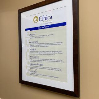 A framed document titled 'Ethica' mounted on a beige wall, displaying guidelines or principles.