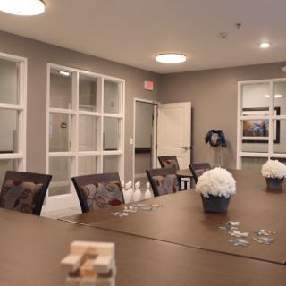 A well-organized meeting room with a conference table, decorated with flowers and a jenga game piece.