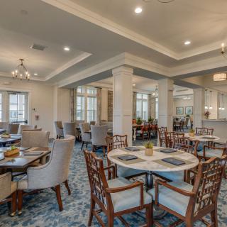 Elegant dining area with well-arranged tables, plush chairs, and sophisticated lighting.