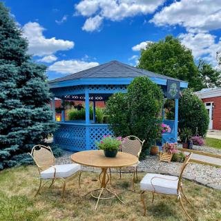 A serene outdoor space featuring a blue gazebo surrounded by greenery, perfect for relaxation.
