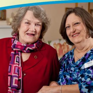 Two women smiling together indoors.
