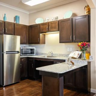 A modern kitchen with dark wood cabinets, stainless steel appliances, and a bright countertop.