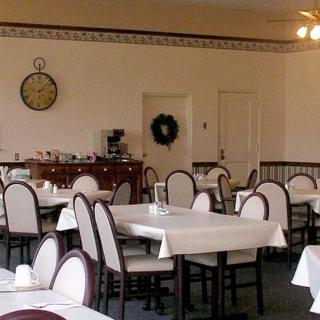 An empty dining room with neatly arranged tables and chairs.