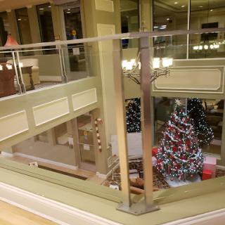 A beautifully decorated Christmas tree in a modern shopping mall, showcasing vibrant holiday lights and a festive atmosphere.