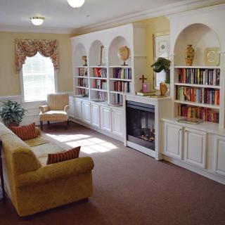 A cozy living room with built-in bookshelves, a fireplace, and comfortable seating.