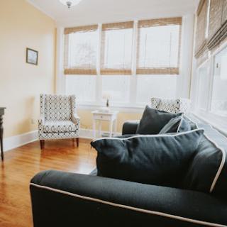 A cozy living room featuring comfortable seating and ample natural light.