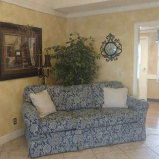 A cozy living room with a patterned sofa, decorative cushions, and wall art.