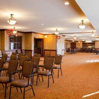 A spacious event room set up with chairs, featuring warm lighting and a cozy atmosphere.