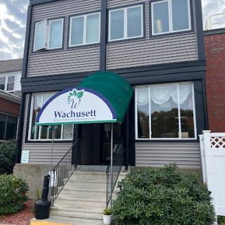 The entrance of a multi-story building with an awning, showcasing the name 'Vashtinett'.