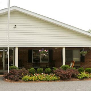 A charming residential building with a welcoming front porch and well-maintained landscaping.