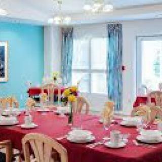 A brightly colored dining room with tables set for guests.