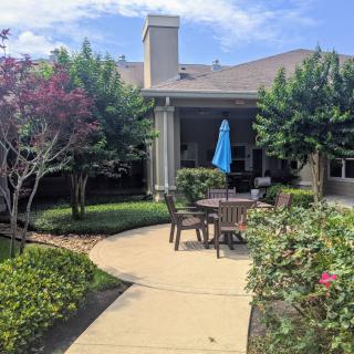 A peaceful garden patio with outdoor seating and an umbrella.
