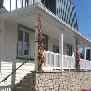 A house with a porch featuring columns and corn stalk decorations.