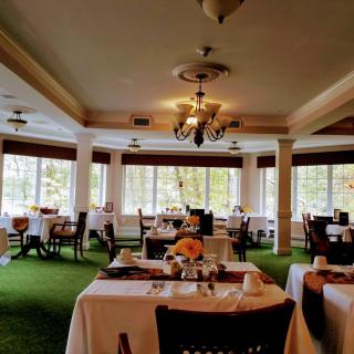 An elegant restaurant interior with neatly arranged tables and large windows.