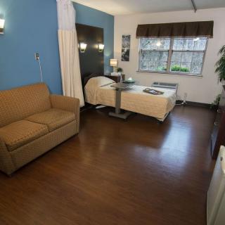 A modern hospital room with a bed and couch.