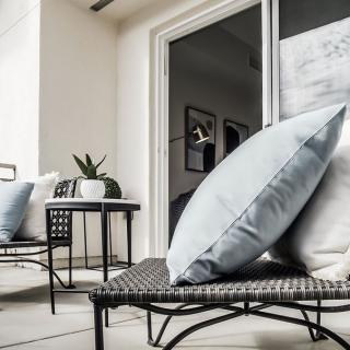 A modern outdoor patio with comfortable cushions and stylish furniture.