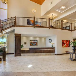 A spacious and modern lobby with a reception desk and balcony.