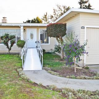 A single-story house with a wheelchair-accessible ramp leading to the front door.